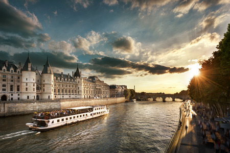Consiergerie, Pont Neuf and Seine river with tour boat at sunny summer sunset, Paris, Franceの写真素材