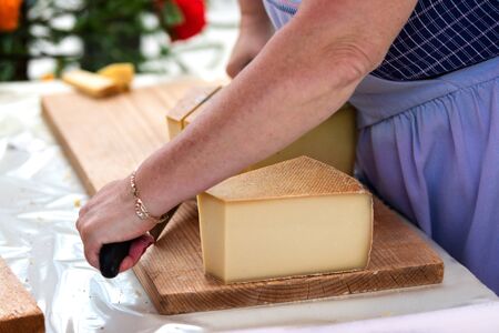 woman is saling swiss gruyere cheese in the market of Charmey, Fribourg, switzerlandの写真素材