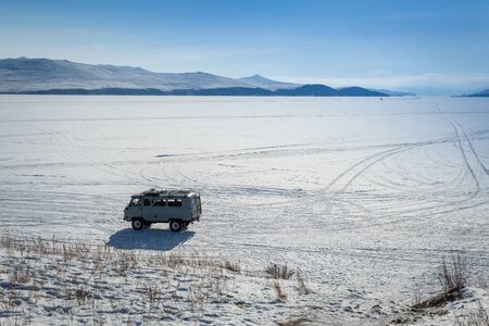 car is driving on ice in lake baikal by winter, Siberia, Russiaの写真素材