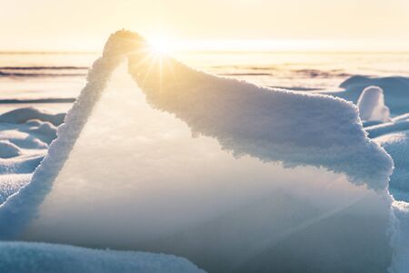 Transparent blue ice floes piled in ice hummocks against a blue sky on a sunny day. Unusual winter...