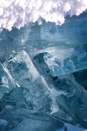 Transparent blue ice floes piled in ice hummocks against a blue sky on a sunny day. Unusual winter...