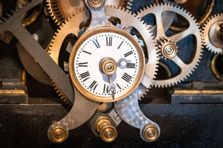 an old clock driving the mechanism for triggering the bells of a church in Franceの写真素材