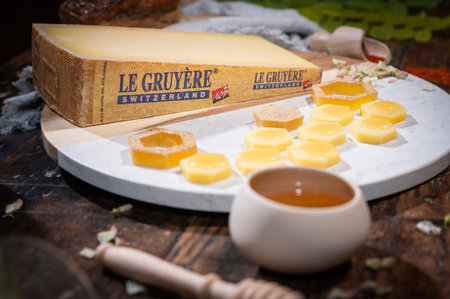 July 12 2022, Lyon, France: Tasted famous swiss cheese: Le GruyÃ¨re d'Alpage with honey for lunch and food experienceのeditorial素材