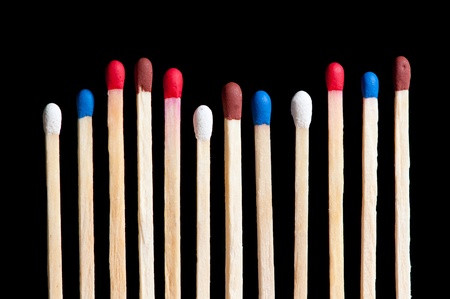 match with white, red, blue and brown head in line, black backgroundの写真素材