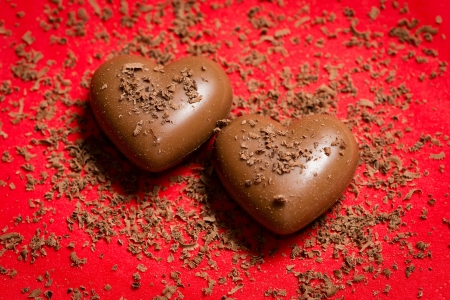 Valentines day card - sweet chocolate hearts on red background