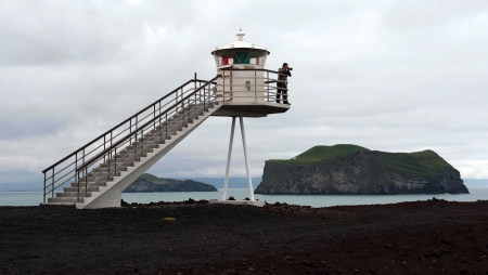 photographer near lighthouse on Heimaey island, Icelandの写真素材