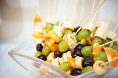 pieces of fruit on the stick ready for chocolate fondue bathの写真素材