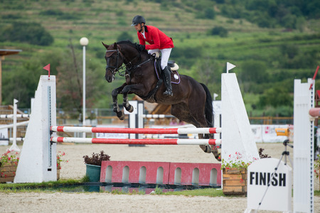 PEZINOK, SLOVAKIA - JULY 29  Jan Cigan jr   SVK  on horse Grancor jumps over hurdle on Rozalka Cup 2014 on July 29, 2014 in Pezinok, Slovakiaのeditorial素材