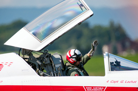 PAYERNE, SWITZERLAND - SEPTEMBER 7: Pilot of Patrouille Suisse aerobatic team waves to spectators of Air14 show in Payerne, Switzerland on September 7, 2014のeditorial素材