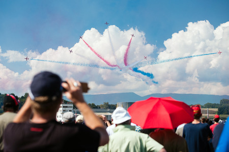 PAYERNE, SWITZERLAND - SEPTEMBER 6: Spectators gaze at Red Arrows aerobatic team flight on AIR14 airshow in Payerne, Switzerland on September 6, 2014のeditorial素材
