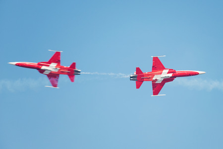 PAYERNE, SWITZERLAND - SEPTEMBER 6: Planes of Patrouille Suisse aerobatic team members are crossing in close distance on AIR14 airshow in Payerne, Switzerland on September 6, 2014のeditorial素材