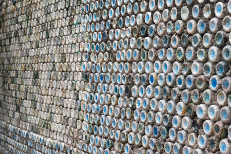 Bottle recycling: plastic bottles which have been set in concrete to form a bottle wallの写真素材