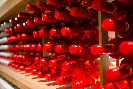 Bottles of pink wine on shelf in wineryの写真素材