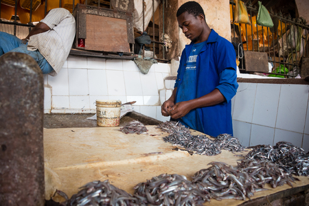 STONE TOWN, ZANZIBAR - DEC 31, 2017: Sellers prepare fresh fish and seafood for sale at Darajani Market in Stone Town, Zanzibarのeditorial素材