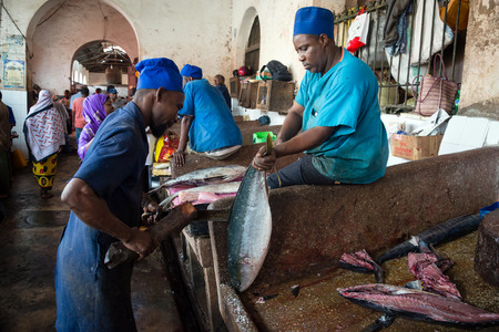 STONE TOWN, ZANZIBAR - DEC 31, 2017: Sellers prepare fresh fish and seafood for sale at Darajani Market in Stone Town, Zanzibarのeditorial素材