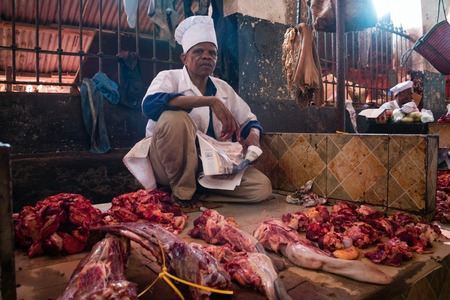STONE TOWN, ZANZIBAR - DEC 31, 2017: Seller offers fresh beef meat at Darajani Market in Stone Town, Zanzibarのeditorial素材