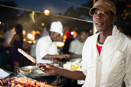 STONE TOWN, ZANZIBAR - DEC 31, 2017: Man selling street food at Forodhani Garden in Stone Town, Zanzibarのeditorial素材