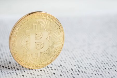 Crypto currency coin - golden Bitcoin on black and white binary 1 and 0 background