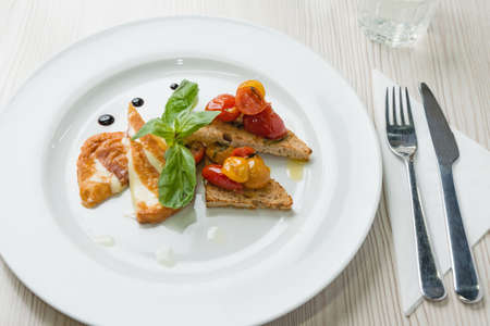 Delicious toast sandwiches with fried cheese, tomatoes, olive oil and basil