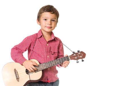 young adorable boy playing the ukulele, isolated on white background with space for text