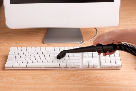 Cleaning of a keyboard with a small vacuum cleanerの写真素材