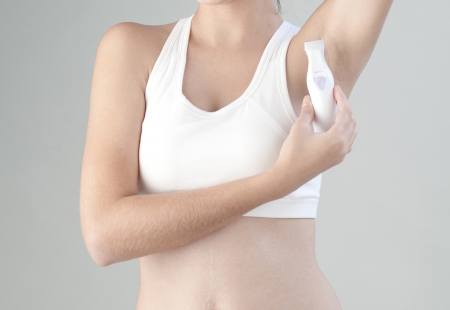 Woman trimming her armpit with electric trimmerの写真素材