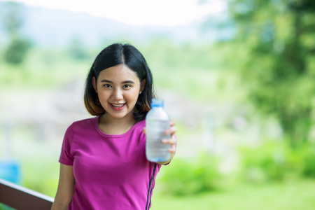 Young asian girl holding a bottle of waterの写真素材