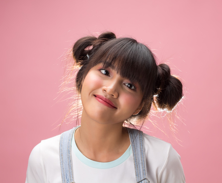 Pretty asian girl in funny face on pink backgroundの写真素材