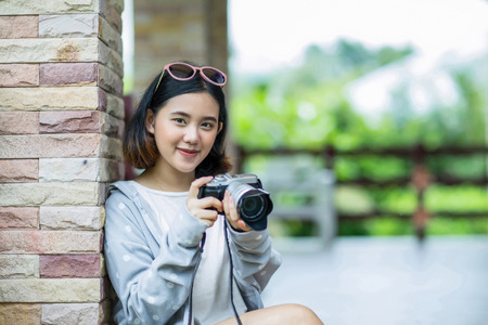 Young asian woman holding a camera with happinessの写真素材