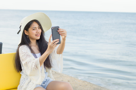 Young pretty asian woman enjoy selfie on the tropical beachの写真素材