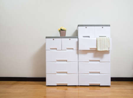 Stacks of white plastic cabinets with drawers on the room backgroundの写真素材