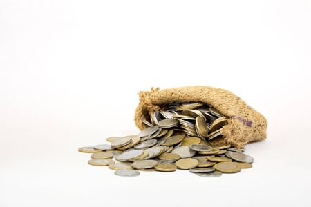 Coins in a small bag isolated on white backgroundの写真素材