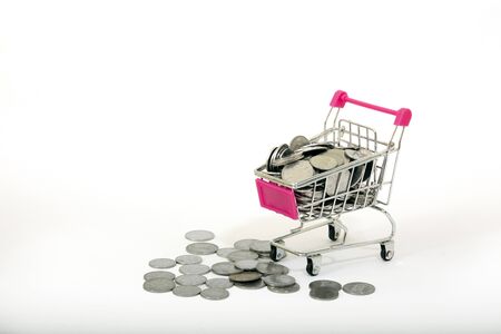 Shopping cart full with coins against white backgroundの写真素材