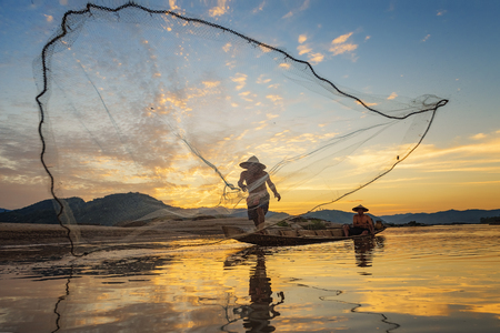 Fishermen fishing at sunset,Fishermen in Thailand.の写真素材