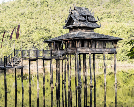 Thailand 's old house built in the river and the mountains , shadows on the water.の写真素材