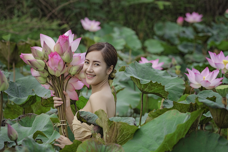 Pretty girl and the sea of red lotus , Thailand ,A beautiful young woman in traditional costume, Thailand .の写真素材