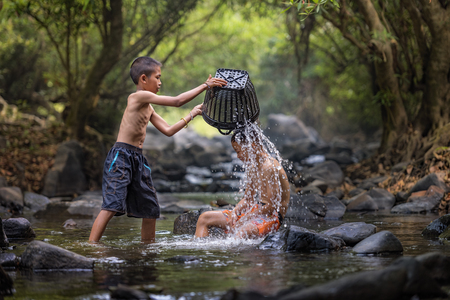 Children play on the river.の写真素材