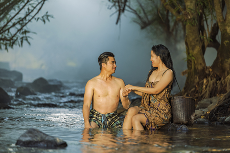couple swimming with fun in natural waterfall pool.の写真素材