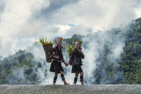 The tribes were crossing the river after returning from work on the mountain.の写真素材