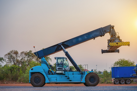 Cranes truck are lifting containers from trucks to freight by trainLogistics and transportation of...