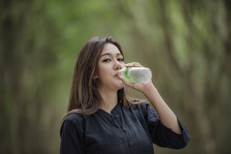 Drink clean water for good health,Women drink natural mineral water refreshing.の写真素材