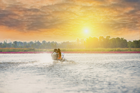 Tourists take a boat out of the evening shore,beautiful sunset in the river landscape,reflection of sky and river.の写真素材