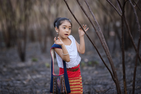 Little Asian girl in the green pasture,Little girl running on meadow with sunset,Happy asian child...