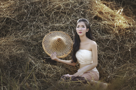 View of young woman famers harvesting rice in a field.の写真素材