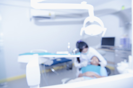 Blurred image of the dentist office, medical background.Dentist examining a patient's teeth in the dentist. The concept of dental treatment in a dental clinic.の写真素材