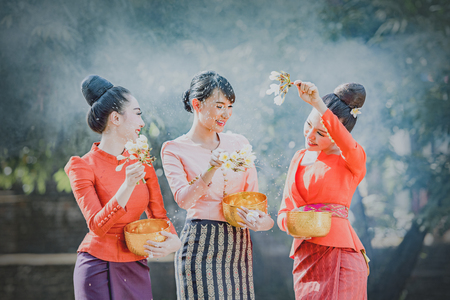 Thai girls and laos girls splashing water during Songkran festival,Water blessing ceremony of adults,Buddha statue water ceremony in songkran festival,Thailand traditional.の写真素材