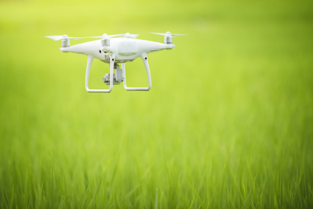drone copter flying with digital camera, Flying camera take a photo and video with professional camera takes pictures view of the mountains,Electric drone flies in the sky with green nature backgrounの写真素材
