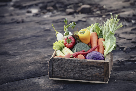 Fresh organic vegetables. Food background. Healthy food from garden. Adult Farmer Holding Fresh Local Vegetable.Vegetables on wooden background. Bio healthy organic food, herbs and spices.の写真素材