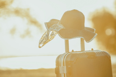 Tourist planning vacation with the help of world map with other travel accessories around.Suitcase and hat with background sunset.Travel concept nature of things ready to be taken on holiday.の写真素材