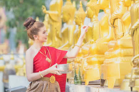 Thai girls and laos girls splashing water during Songkran festival,Water blessing ceremony of adults,Buddha statue water ceremony in songkran festival,Thailand traditional.の写真素材